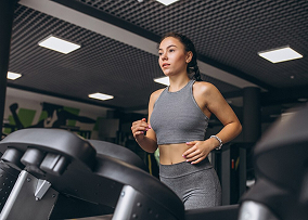 Женщина бежит на беговом дорожке